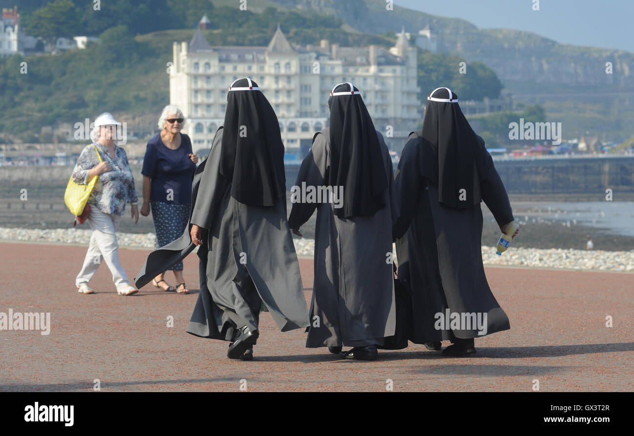 Le donne in abito religioso camminare nuovamente l'integrazione razziale comunità di minoranza etnica bianco razzista burka stile abito di testa coprire REGNO UNITO Foto Stock
