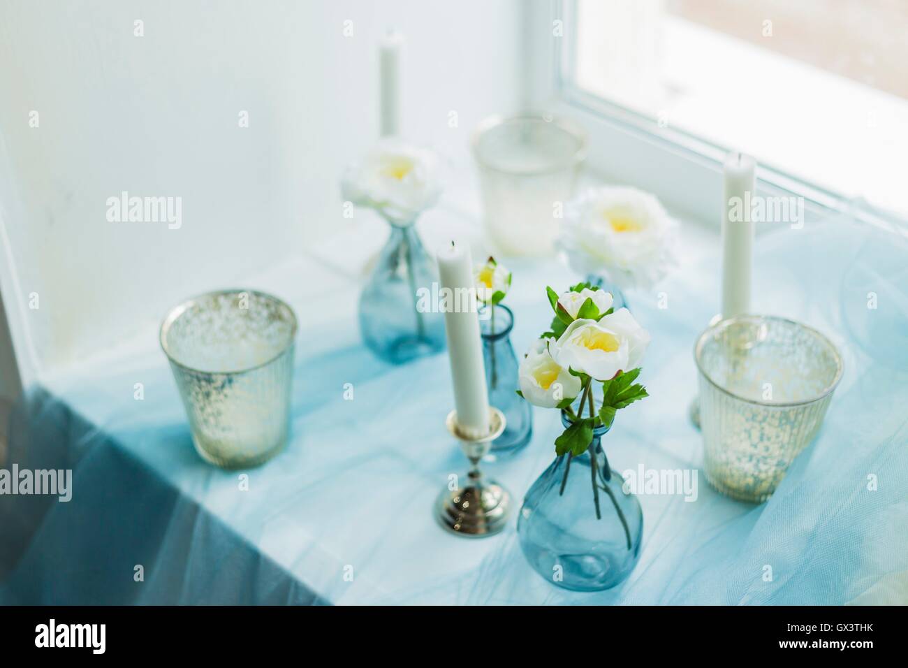Il decor di photostudio - candele bianche, tessile blu Foto Stock