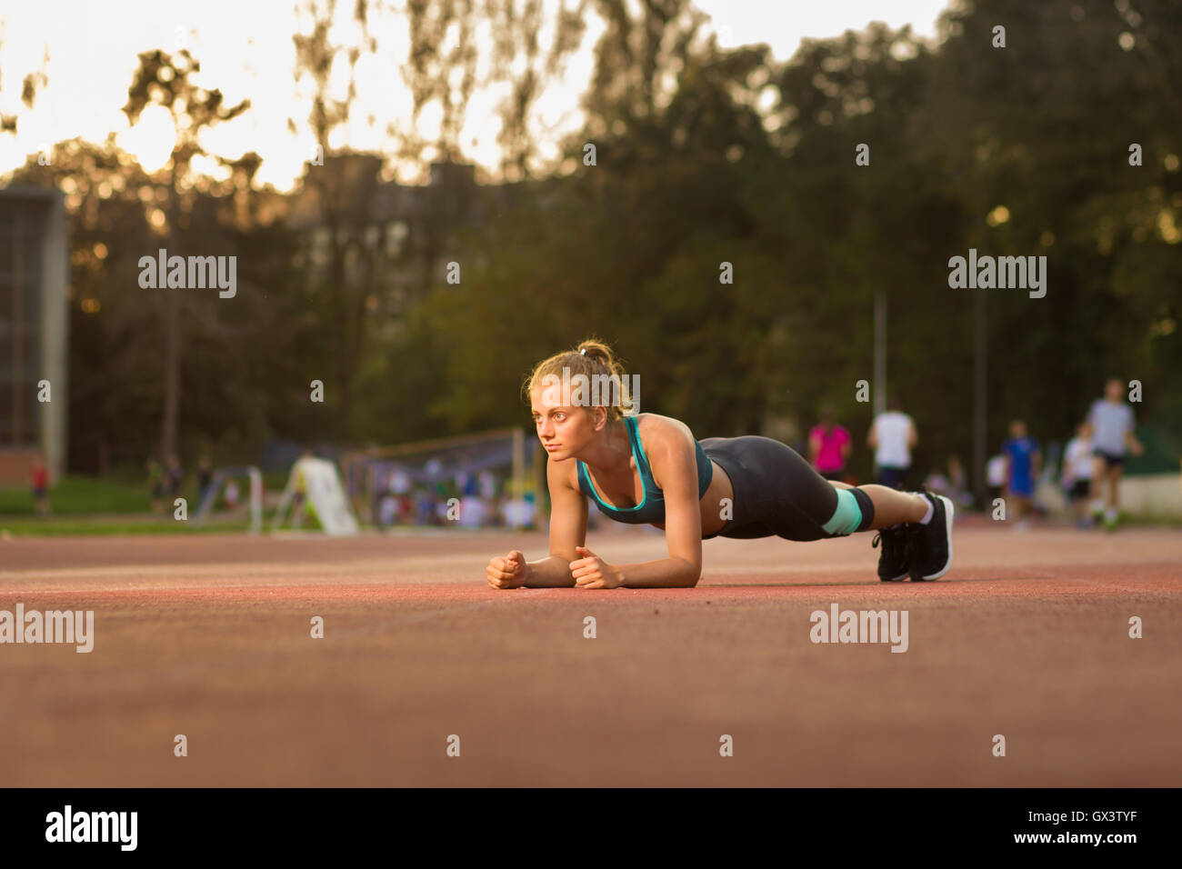 Giovane ragazza adolescente plank sport vestiti alla moda di fantasia giornata di sole tramonto Foto Stock