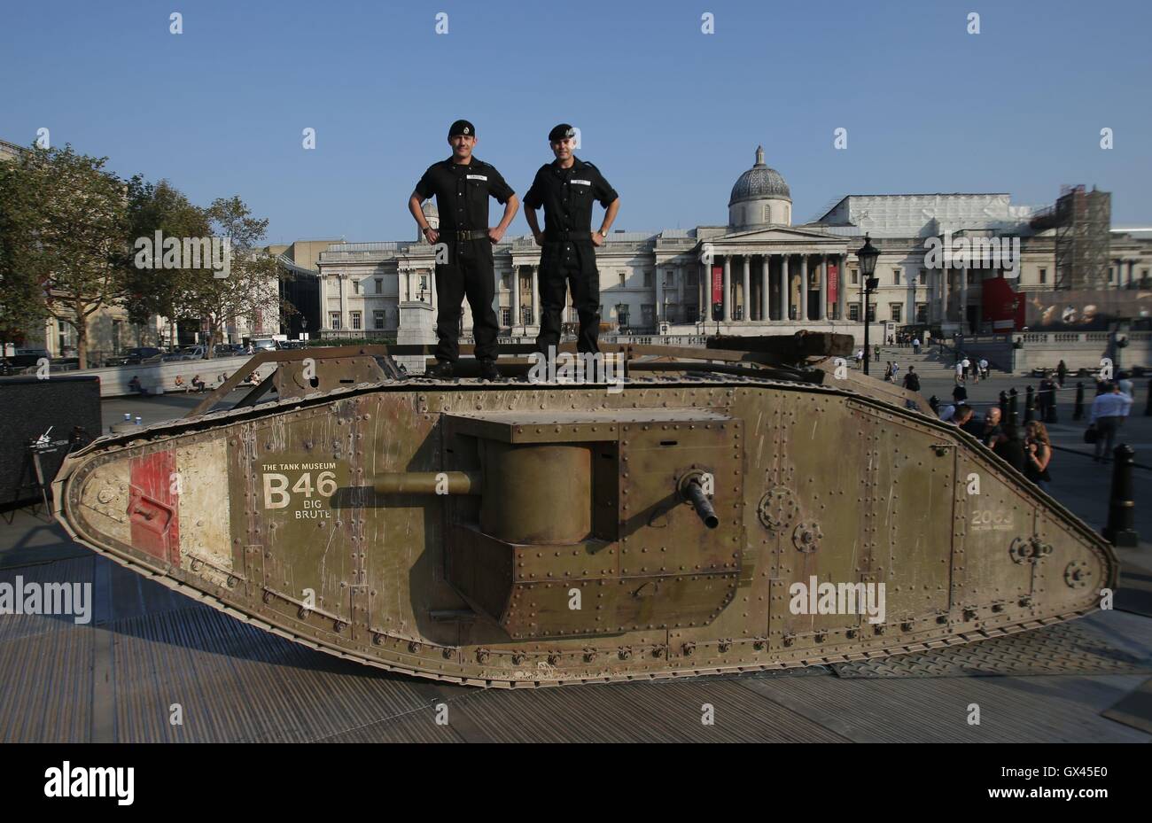 I membri del reale reggimento di serbatoio di stare su una replica Prima Guerra Mondiale Mark IV serbatoio a Londra in Trafalgar Square segna il centenario di un veicolo blindato del primo impiego durante la battaglia della Somme. Foto Stock