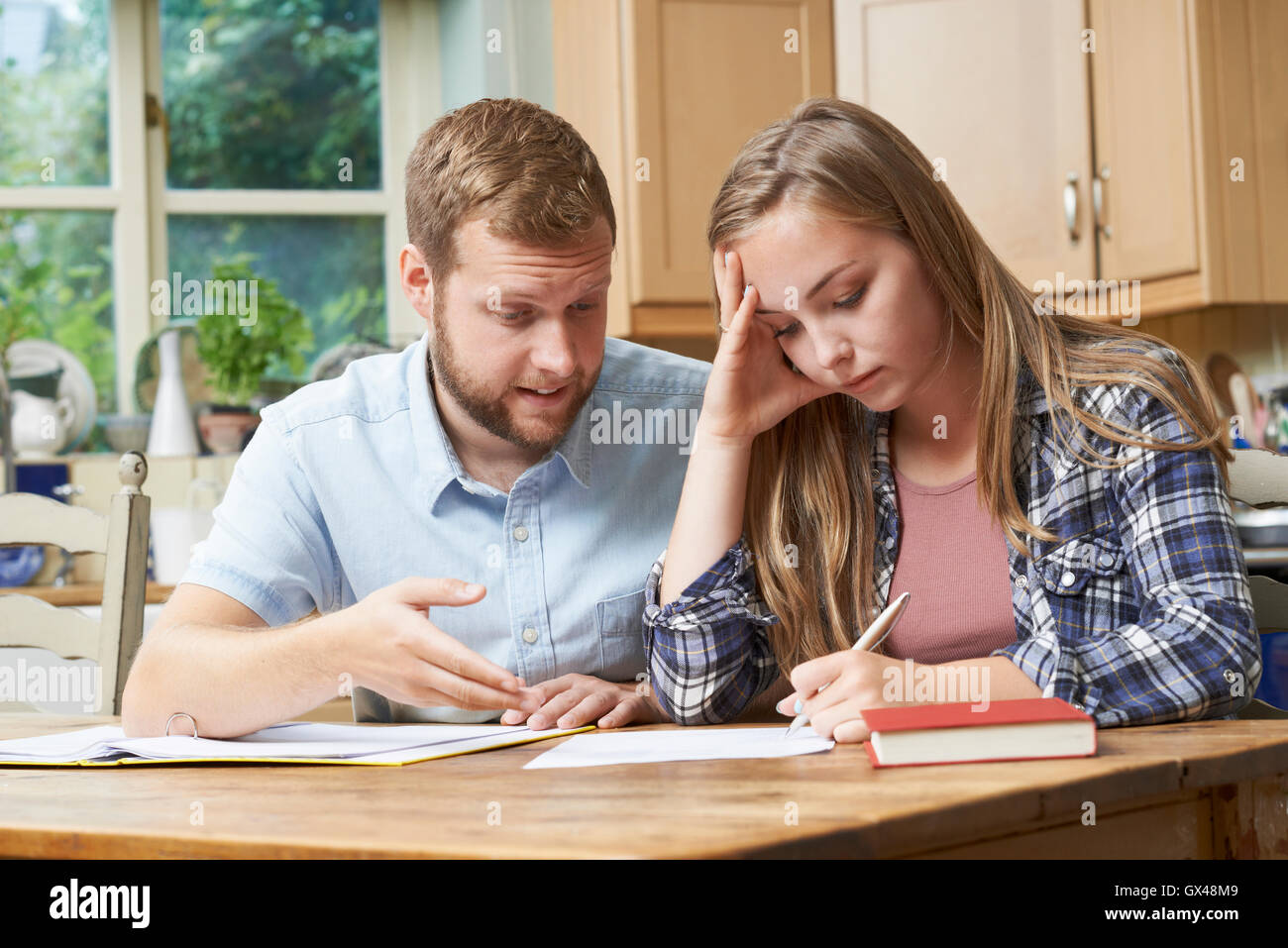 Home maschio Tutor aiutando ragazza adolescente con studi Foto Stock