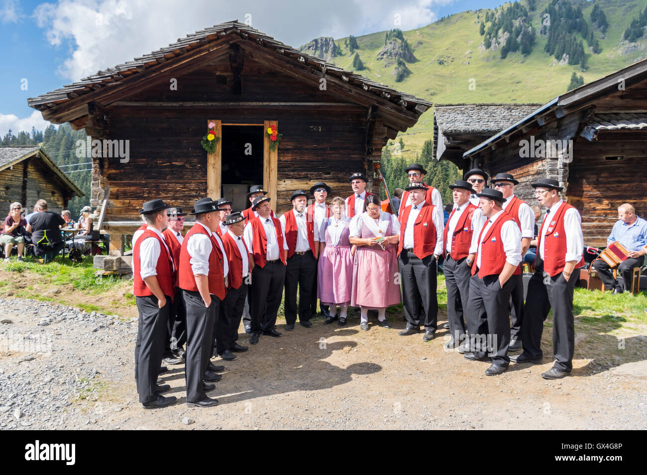 Coro misto "Jodlerklub Muotathal' in indumenti tradizionali yodeling di fronte capannoni. Berner Oberland, Svizzera. Foto Stock