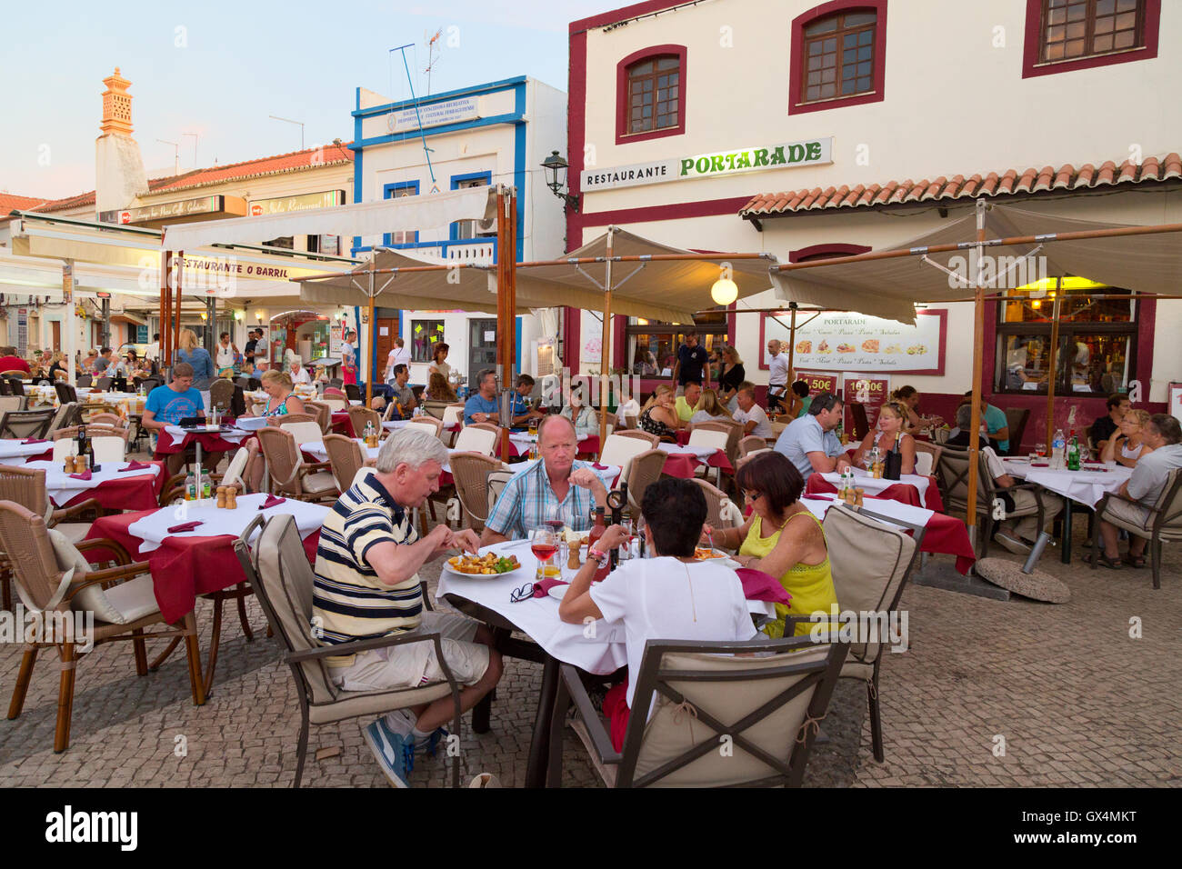 Persone mangiare all'aperto in ristoranti, la piazza principale, Ferragudo, Algarve, Portogallo Europa Foto Stock