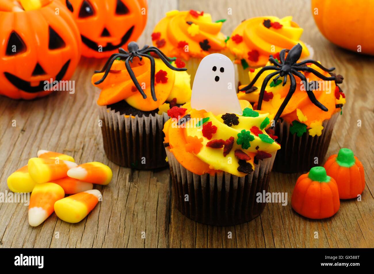 Tortini di Halloween e candy su tavola in legno rustico Foto Stock