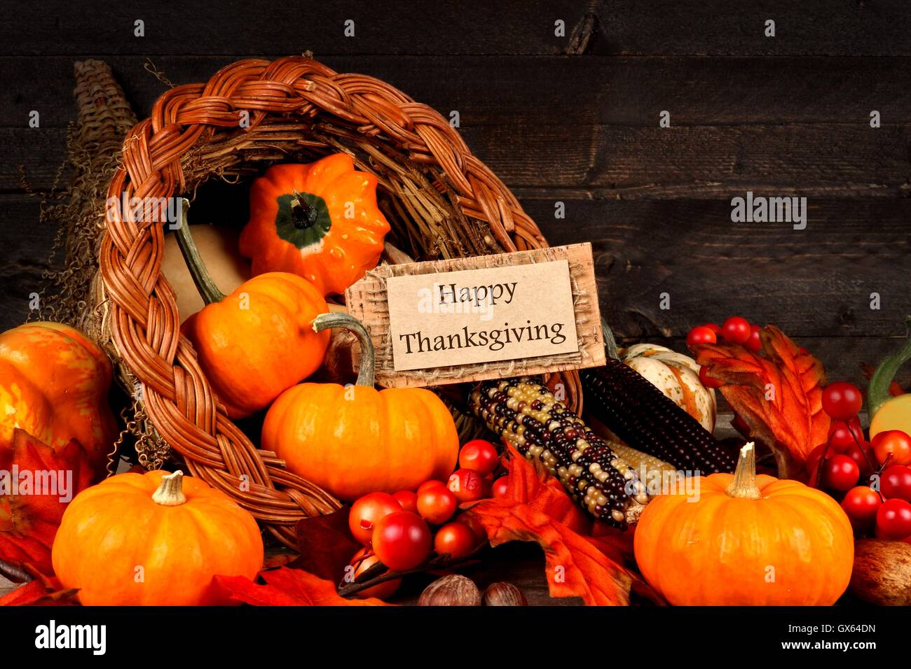 Harvest cornucopia close up con felice regalo di ringraziamento tag su legno scuro dello sfondo Foto Stock