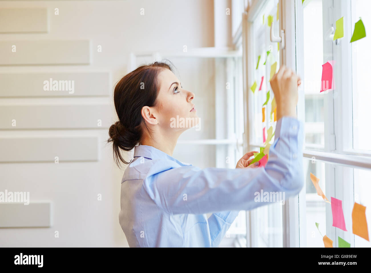 Giovane imprenditrice durante la progettazione creativa in officina Foto Stock