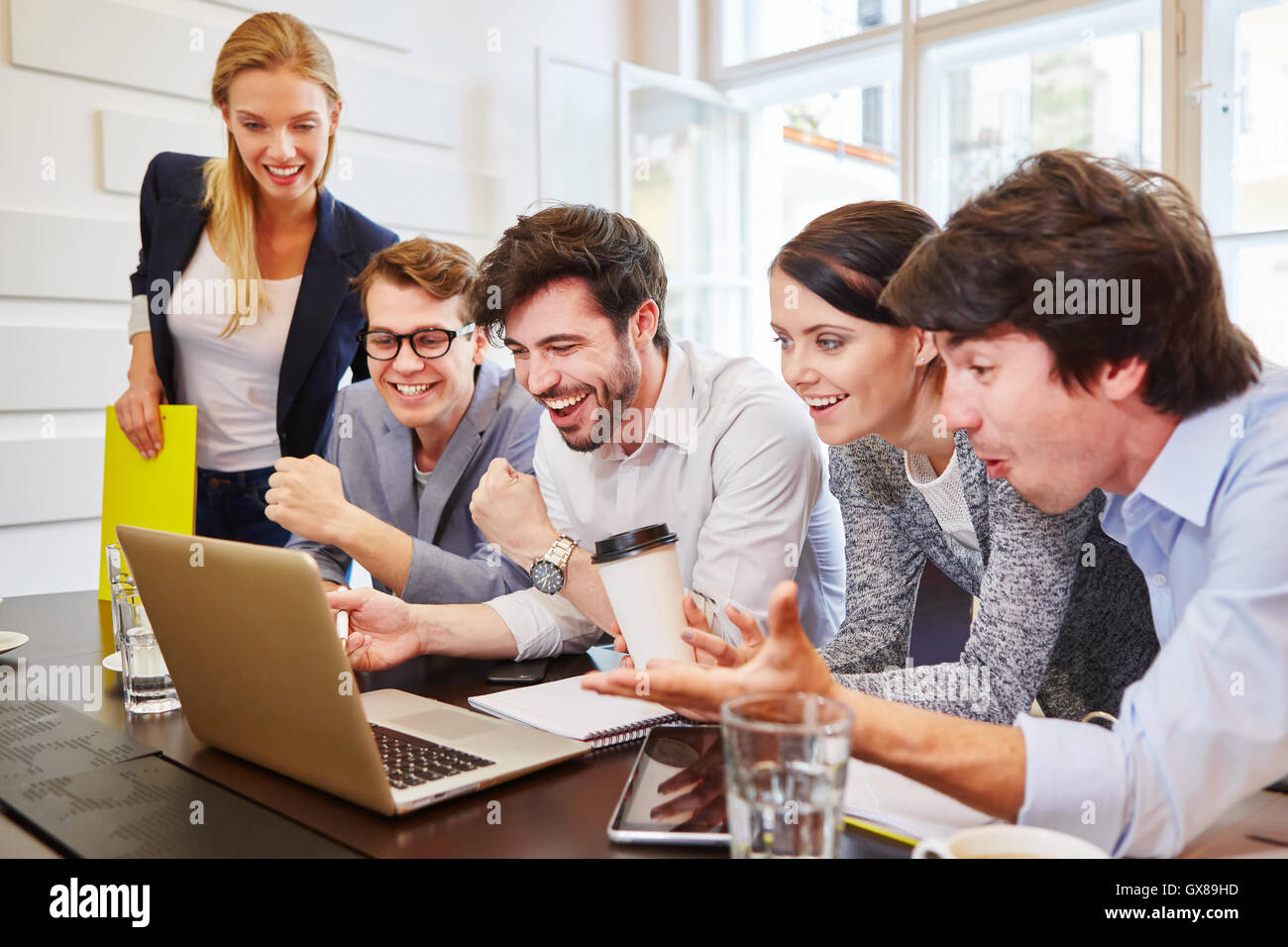 Happy team training con computer e alla ricerca di una soluzione di successo Foto Stock