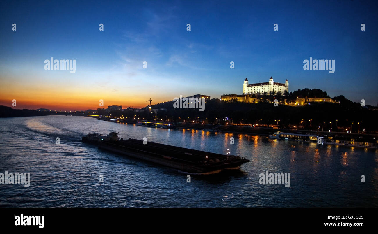 Bratislava Castello Danubio Slovacchia, Barca sul Danubio in Sunset Shipping Trade Europa città fiume Foto Stock
