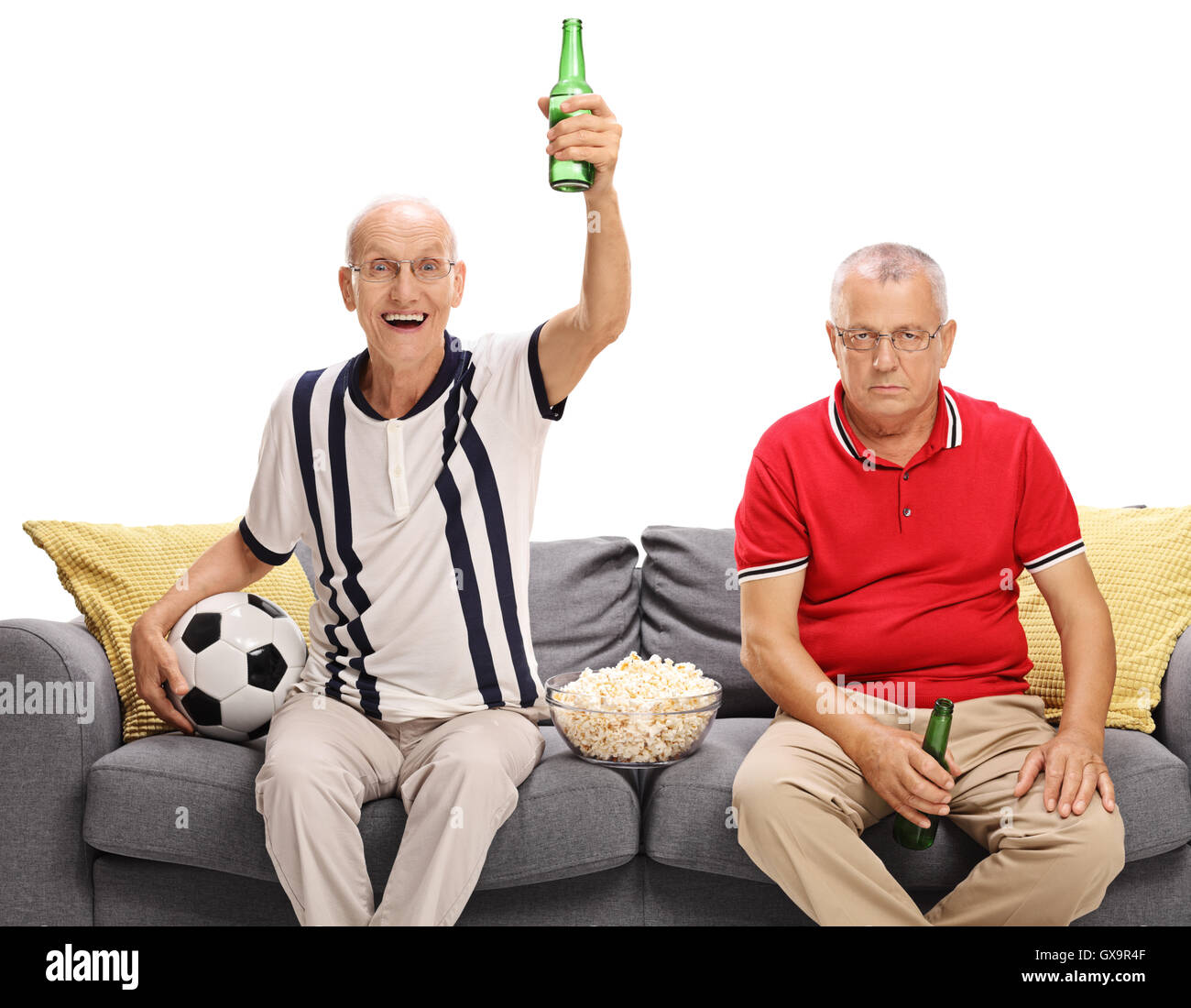 Due uomini maturi guardare il calcio e il tifo per un team diverso isolati su sfondo bianco Foto Stock