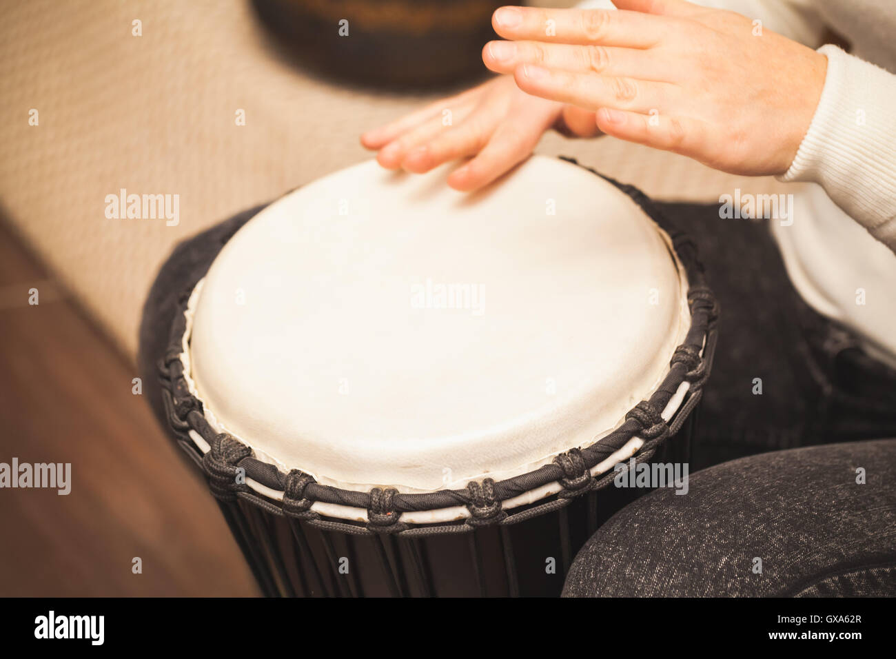 Il batterista gioca sul piccolo tamburo africano, closeup foto con messa a fuoco selettiva Foto Stock