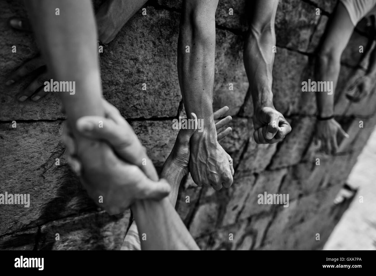 Un colombiano parkour atleta, appeso su i suoi compagni' le mani, si arrampica sulla parete durante un training di Bogotá, in Colombia. Foto Stock