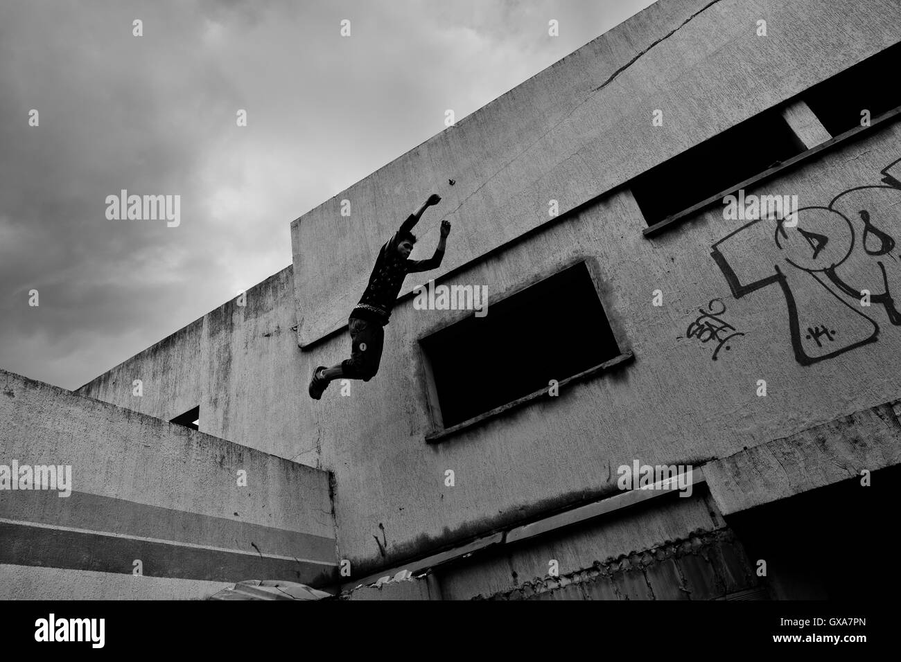 Un colombiano parkour atleta salta dalla parete durante una corsa libera sessione di formazione di più team di Parkour in Bogotá, Colombia. Foto Stock