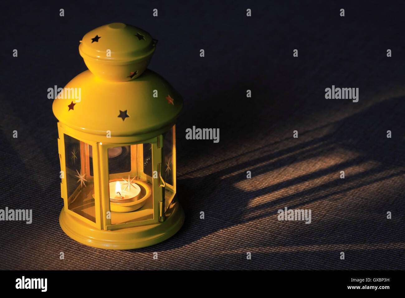 Bella lampada gialla con illuminazione candela su sfondo scuro Foto Stock