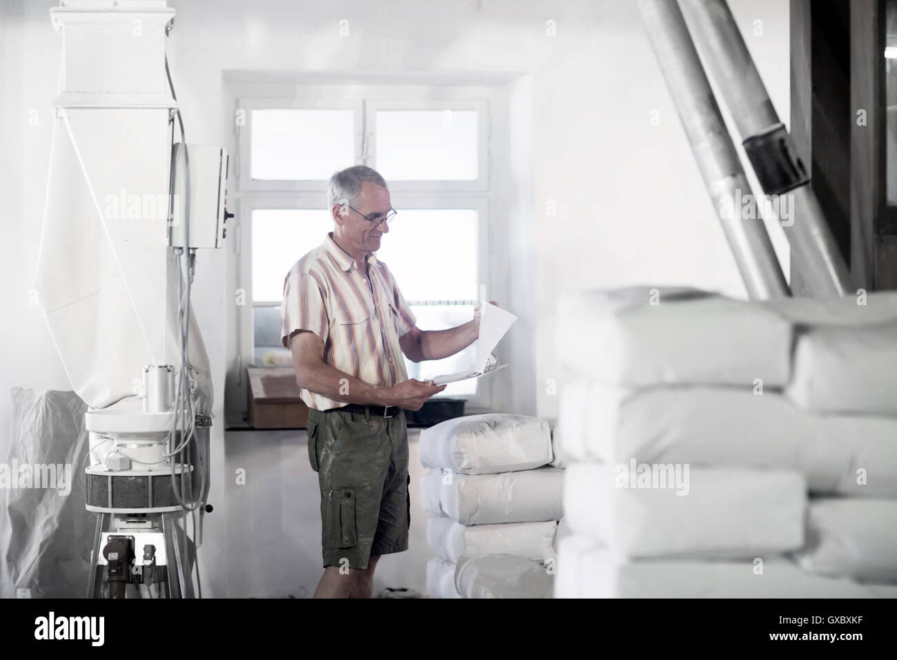 Miller maschio di inventario dei sacchi di farina al mulino di grano Foto Stock