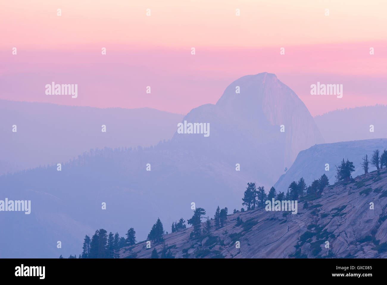 Mezza Cupola al tramonto la montagna obscurred parzialmente dal fumo dal 2014 cane Rock wildfire, Yosemite, California, USA. Foto Stock