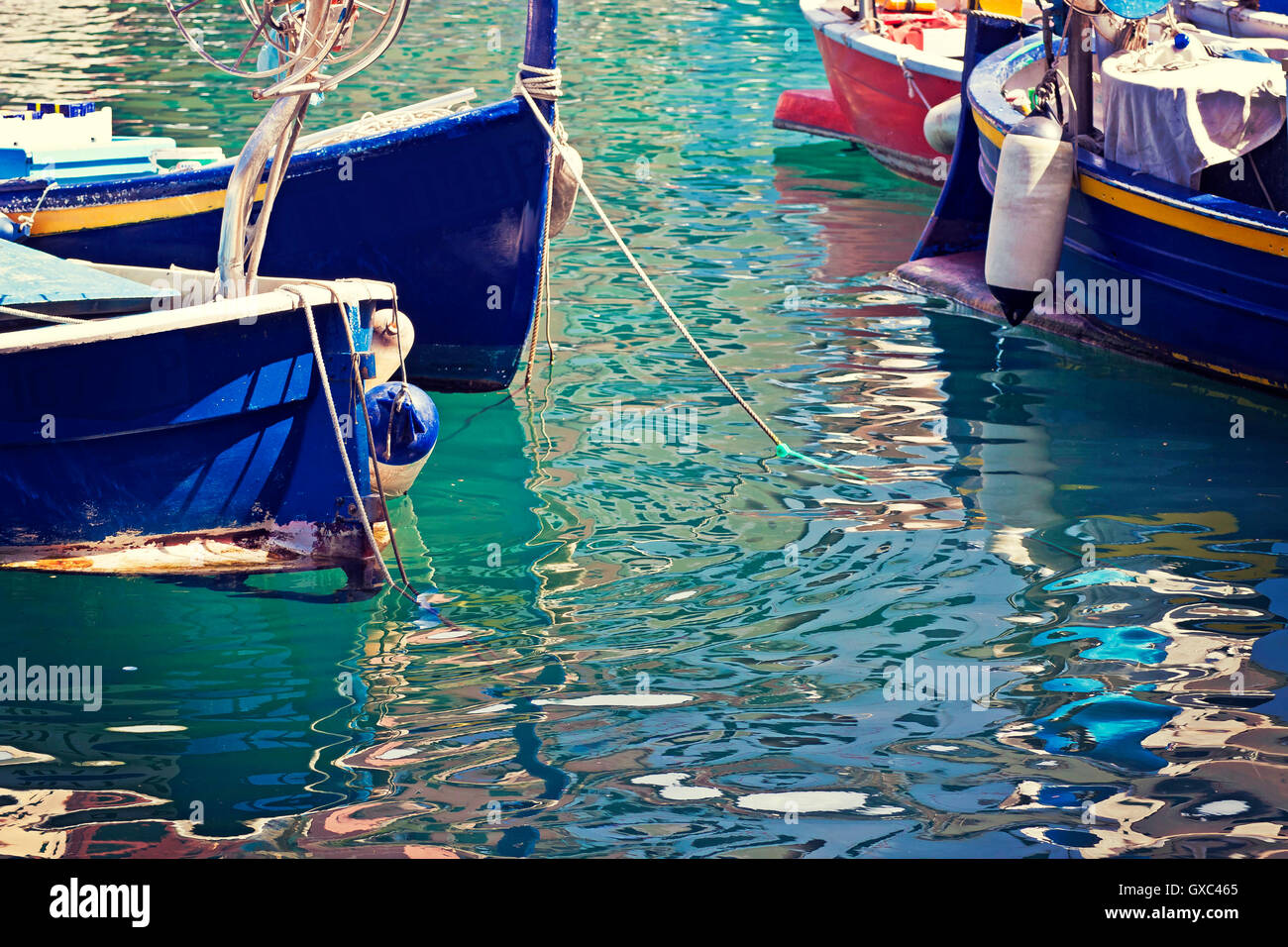 Fantastici colori e riflessi di Camogli acqua di mare con barche di pesce galleggianti al di ancoraggio Foto Stock