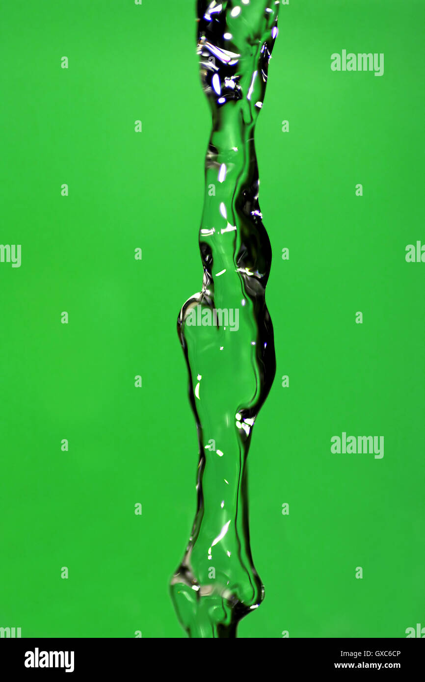 L'acqua che cade giù, Congelati nel tempo con sfondo verde. Foto Stock