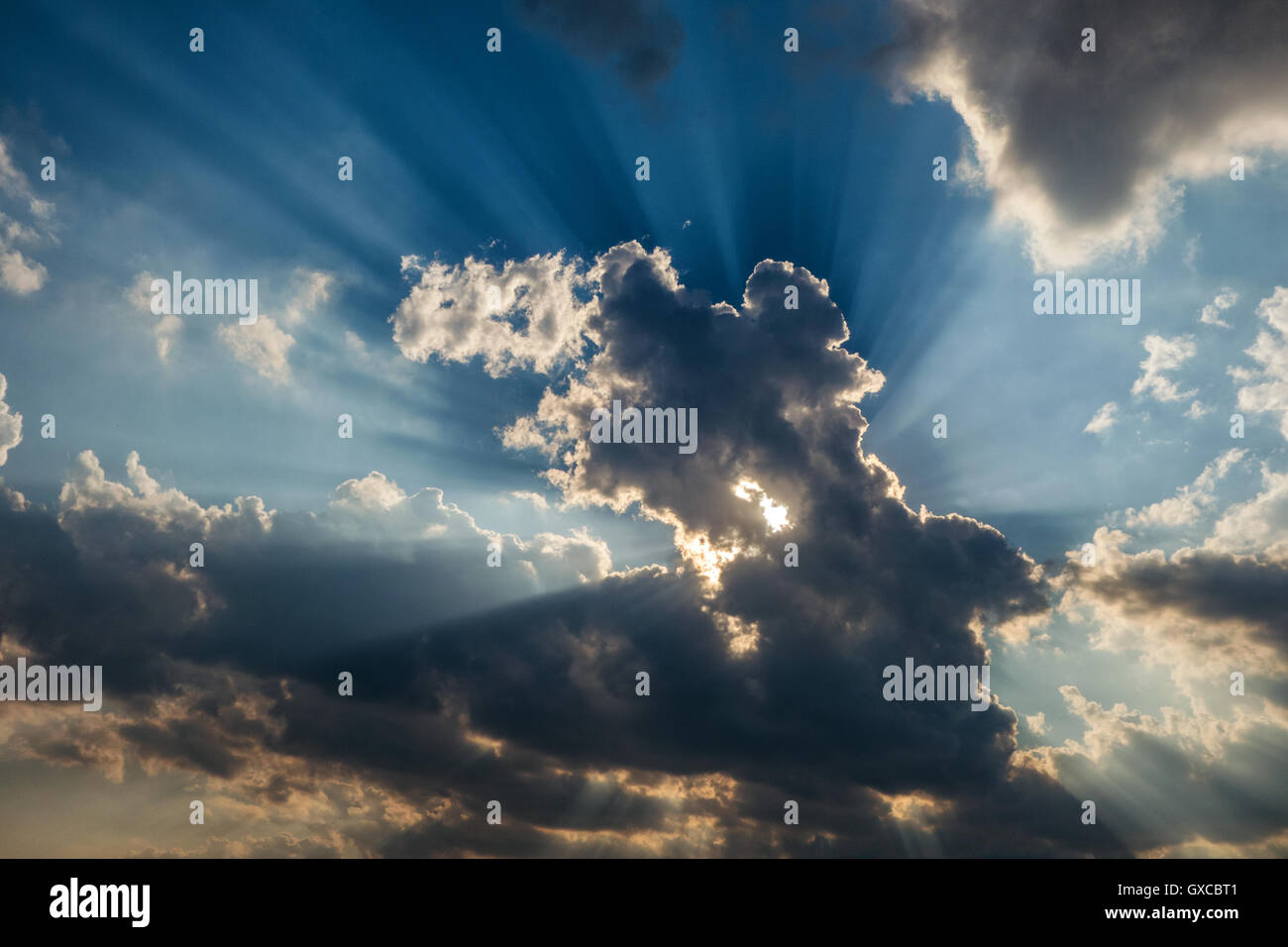 I raggi solari sono suggestivi attraverso le nuvole come un'esplosione Foto Stock