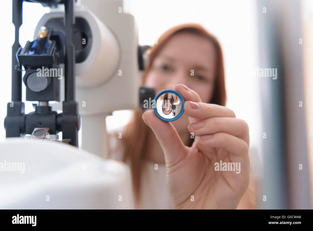 Ottico mantenendo la lente al paziente a occhi small business ottici Foto Stock