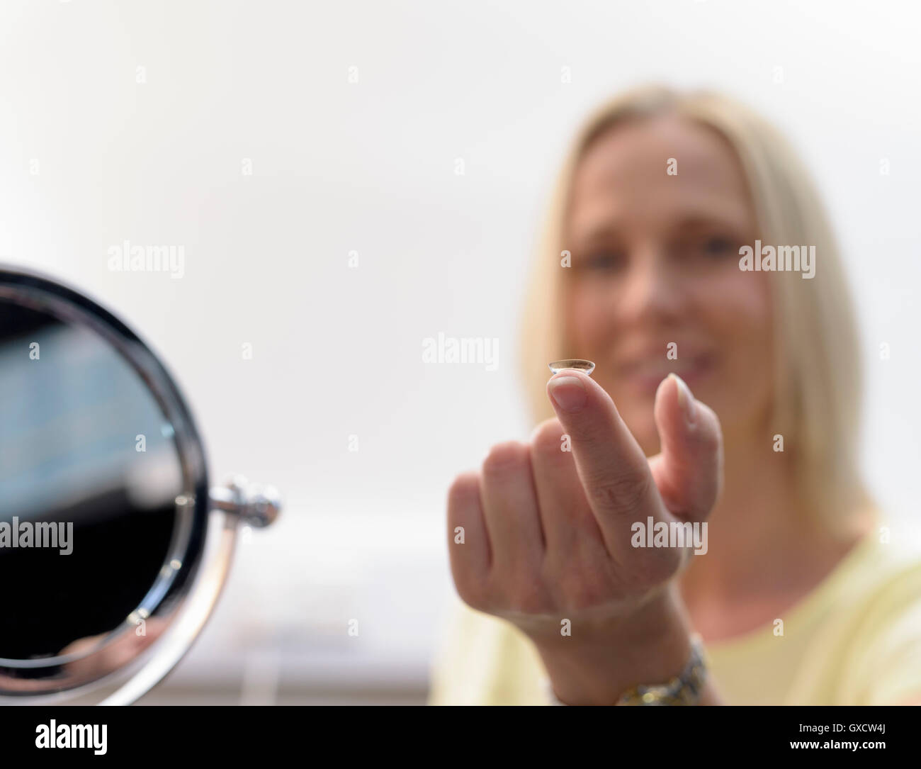 Paziente cercando sulla lente a contatto a small business ottici, close up Foto Stock