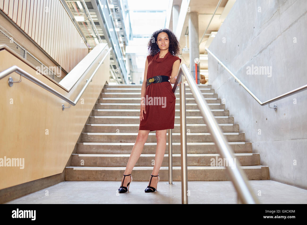 Ritratto di giovane imprenditrice permanente sulla scalinata di office Foto Stock