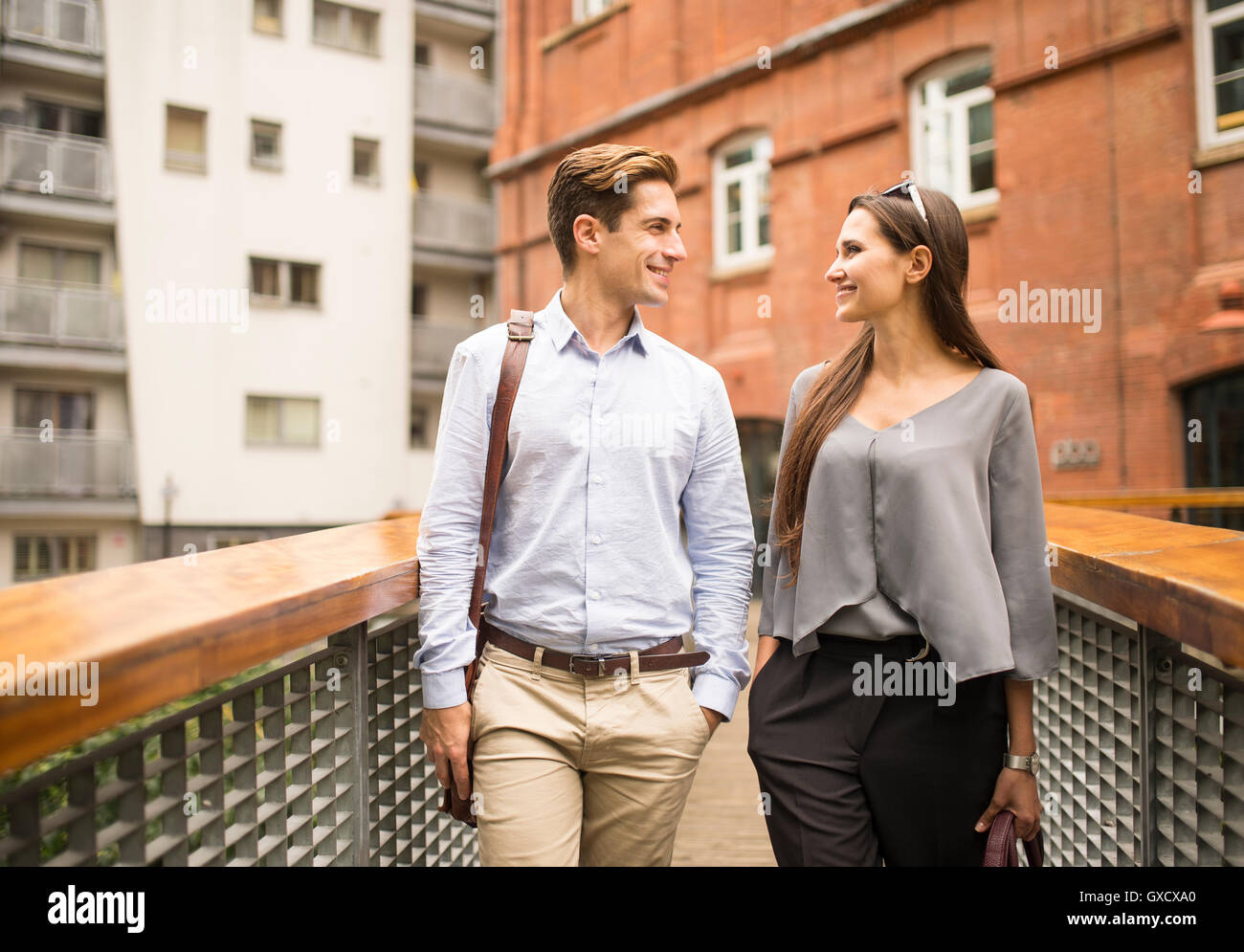 Giovane imprenditrice e uomo in chat su passerella, London, Regno Unito Foto Stock