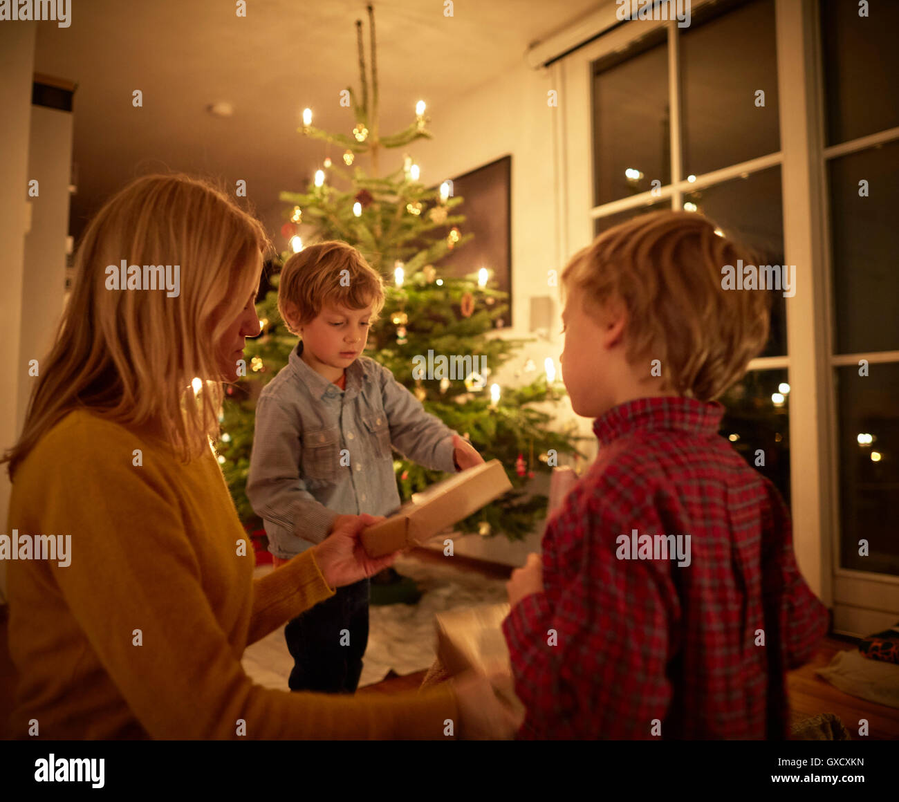Madre e figli seduti a casa a Natale, lo scambio di doni Foto Stock