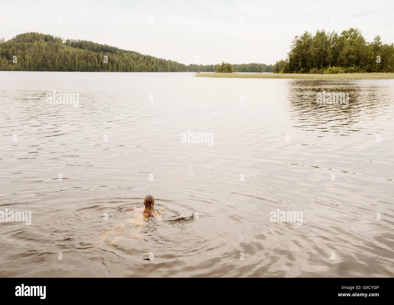 Donna nuotare nel lago di Orivesi, Finlandia Foto Stock