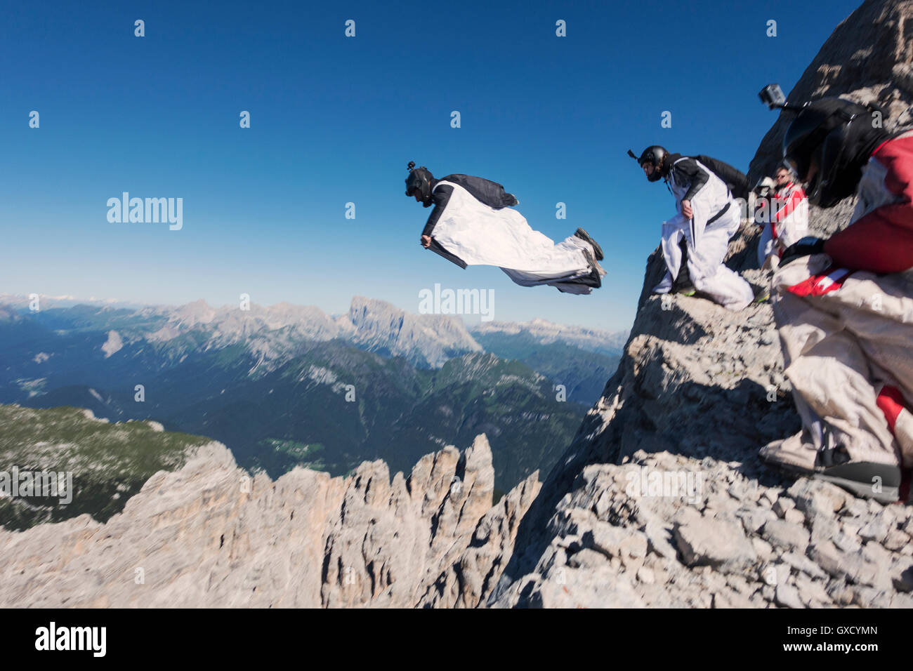 Wingsuit BASE jumping team jumping dalla scogliera, Alpi Italiane, Alleghe, Belluno, Italia Foto Stock