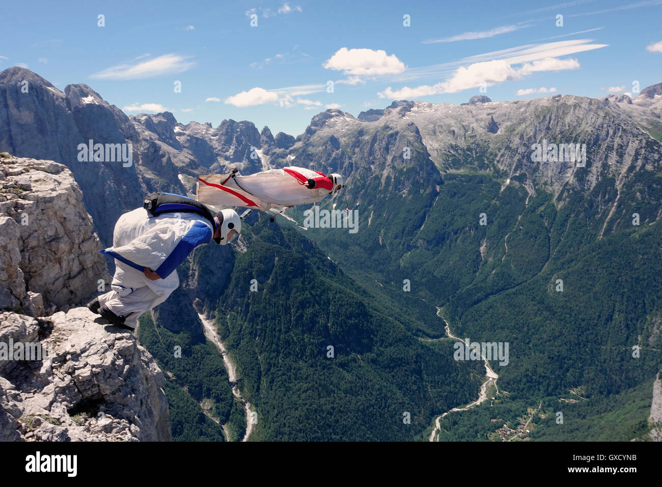 BASE jumping wingsuit piloti stanno saltando insieme da una scogliera e giù per la valle, Alpi Italiane, Alleghe, Belluno, Italia Foto Stock