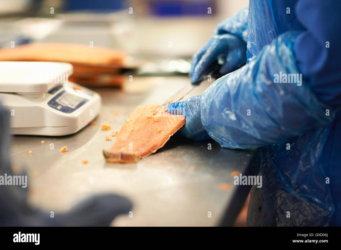 Uomo in smokehouse sfilettatura salmone Foto Stock