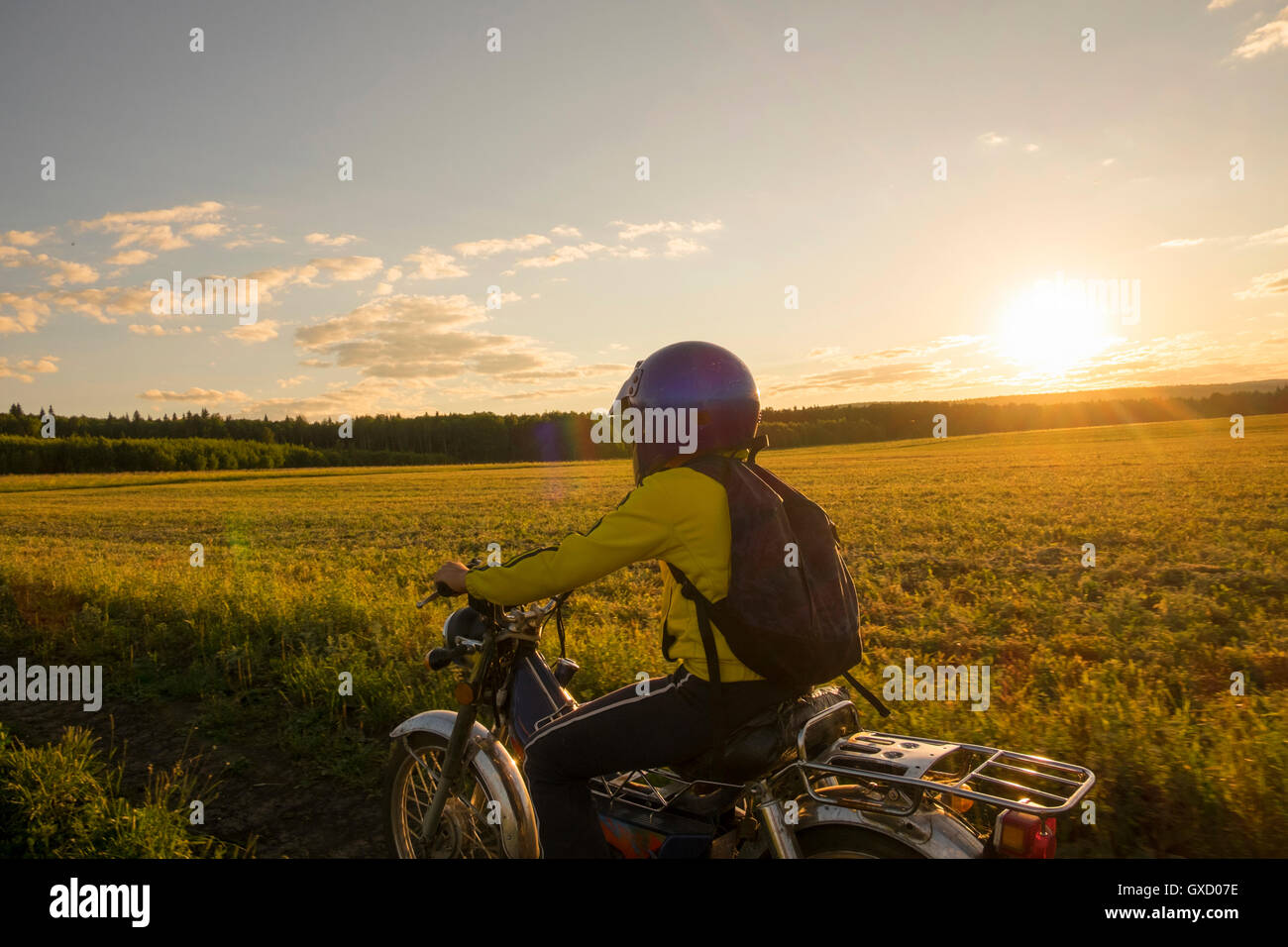 Ragazzo Bicicletta Equitazione attraverso il campo Foto Stock