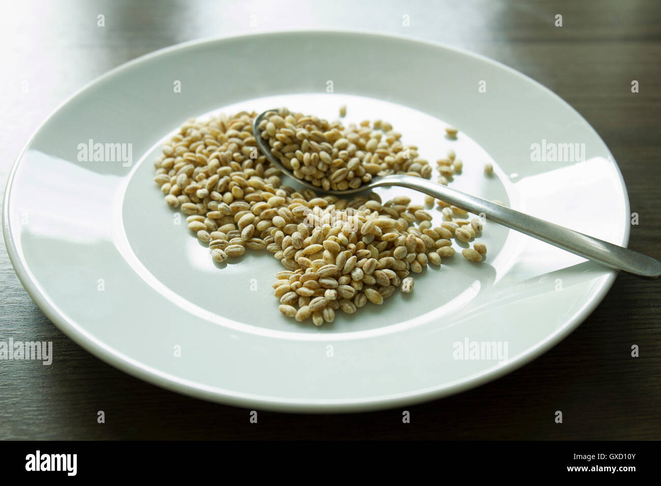 L'orzo in chicchi con paletta sulla piastra Foto Stock
