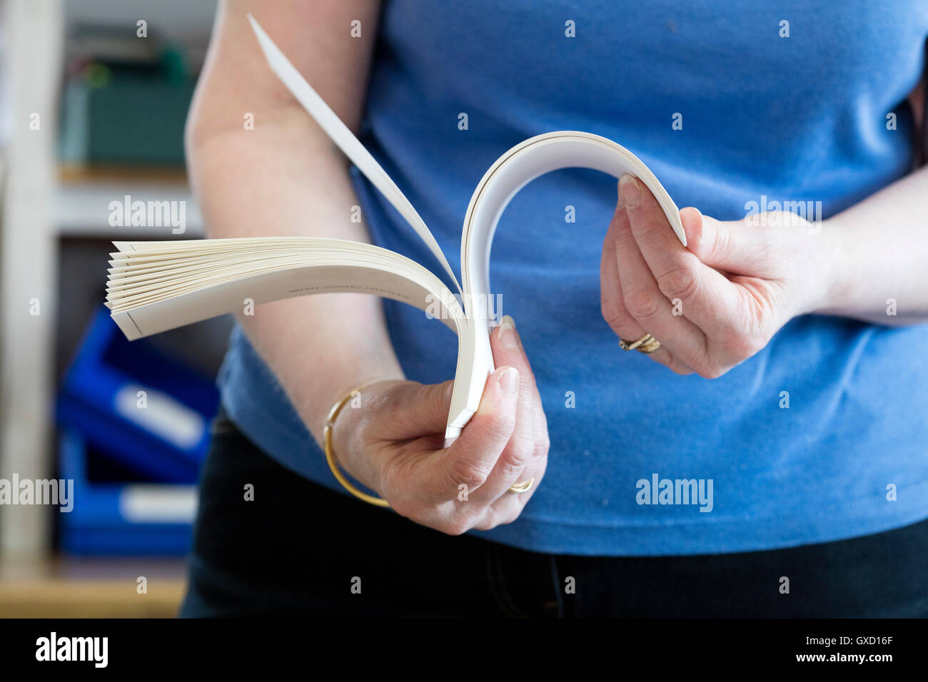 La sezione centrale del lavoratore di sesso femminile che la carta di controllo nella macchina da stampa workshop Foto Stock
