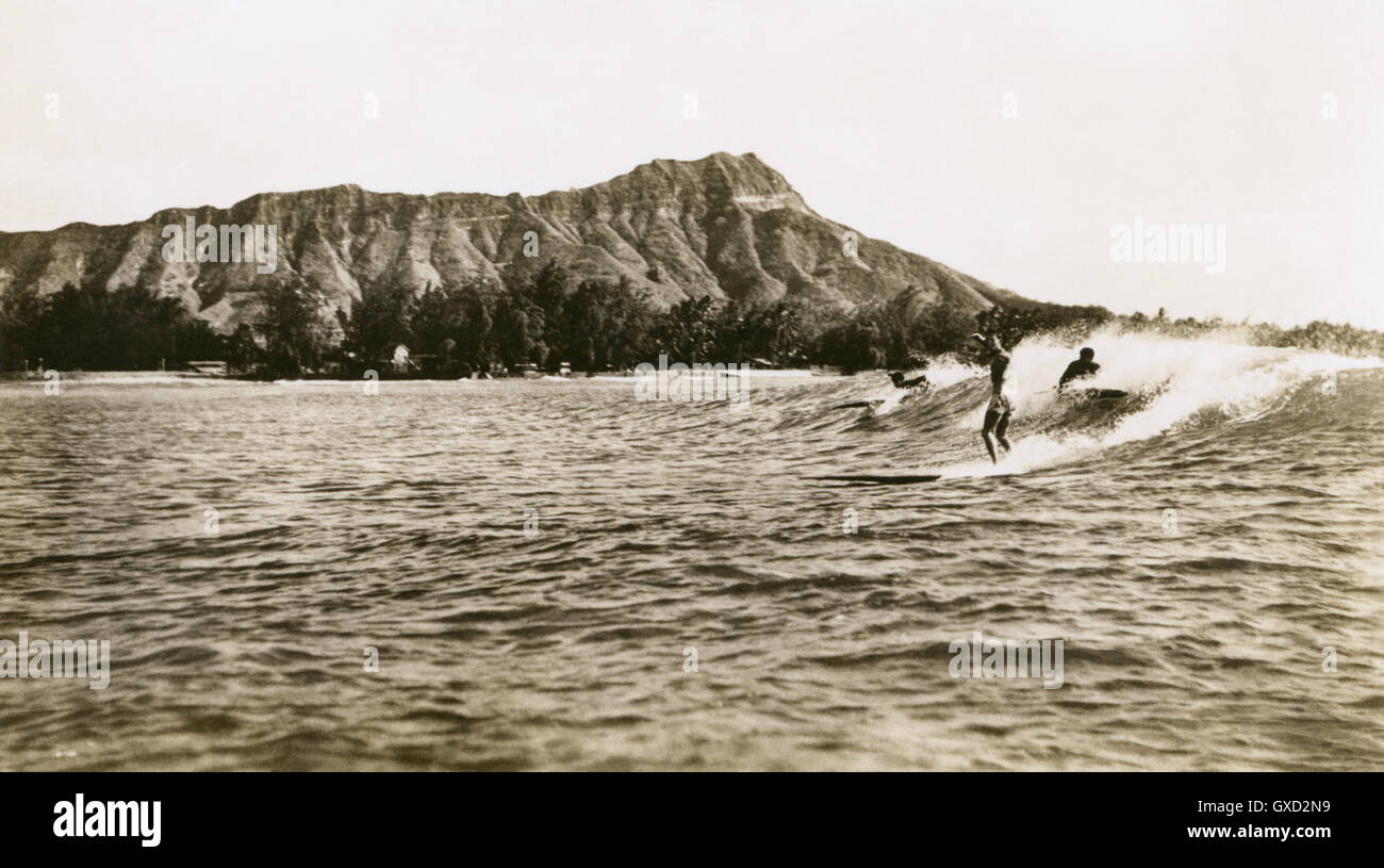 Vintage foto di tre surfisti cavalcare un onda di Waikiki a Honolulu, Hawaii. Foto Stock
