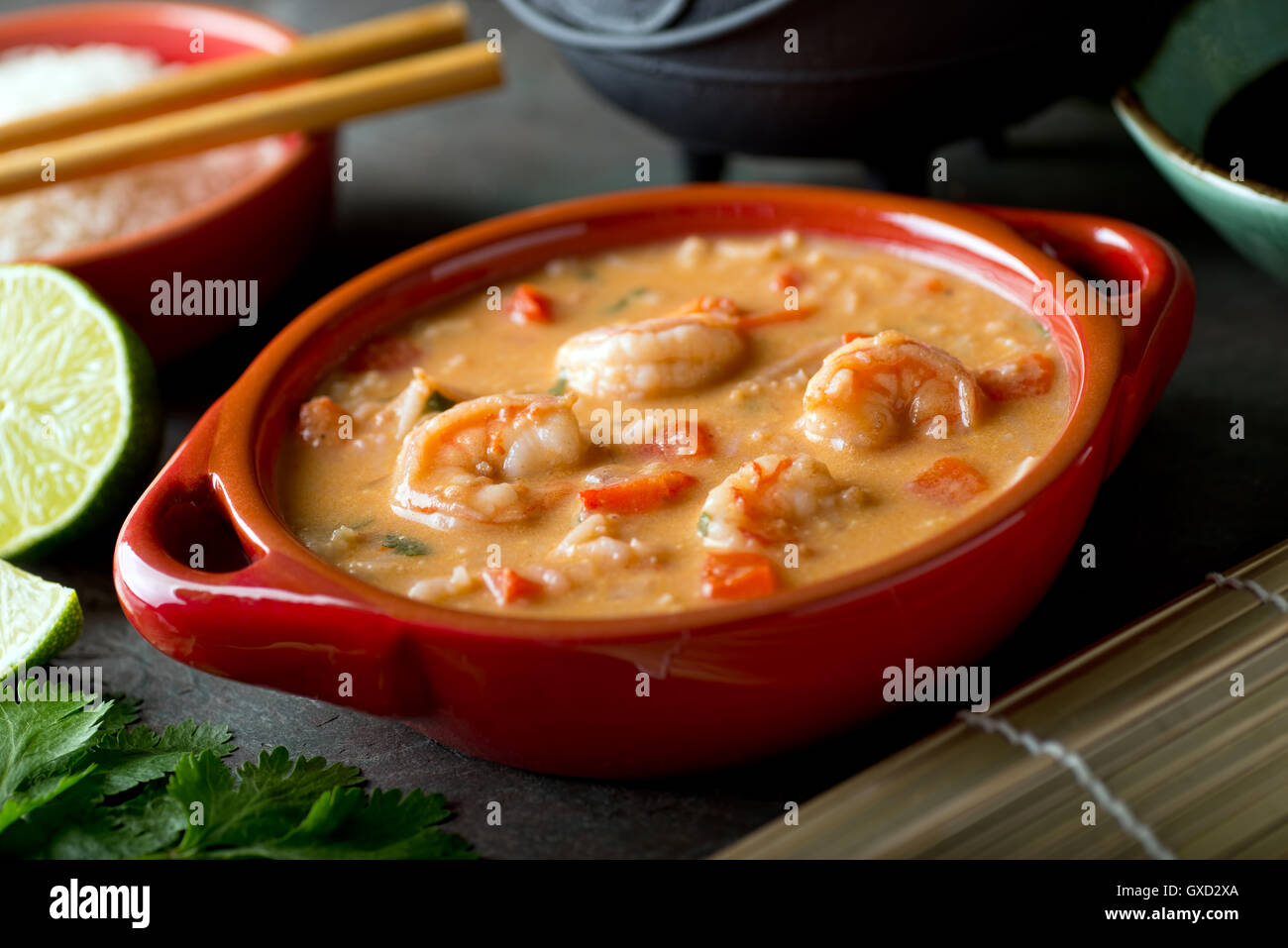 Una tazza di delizioso curry tailandese rossa gamberi in salsa di cocco zuppa di riso. Foto Stock