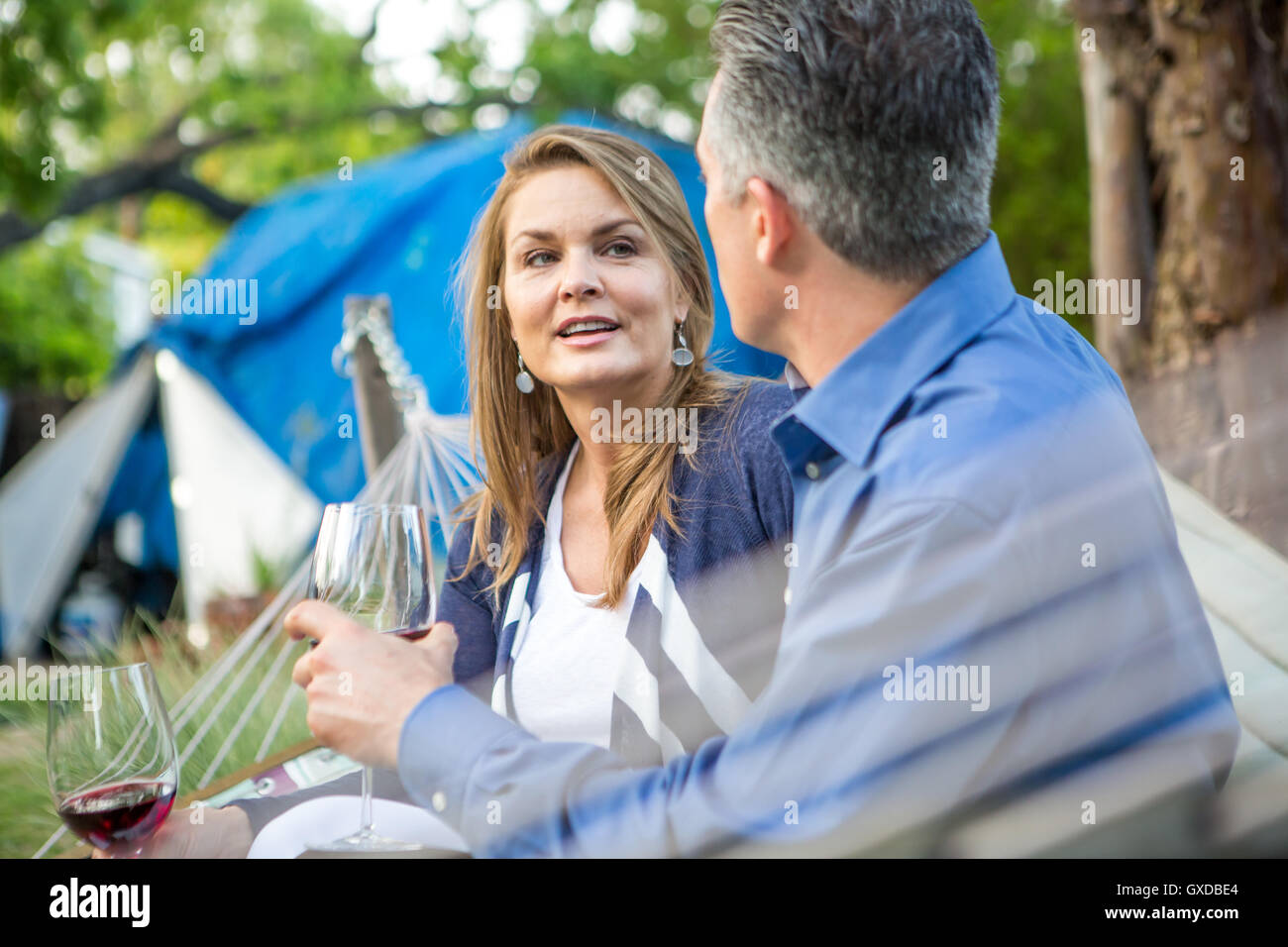 Coppia matura chattare su amaca in giardino partito Foto Stock