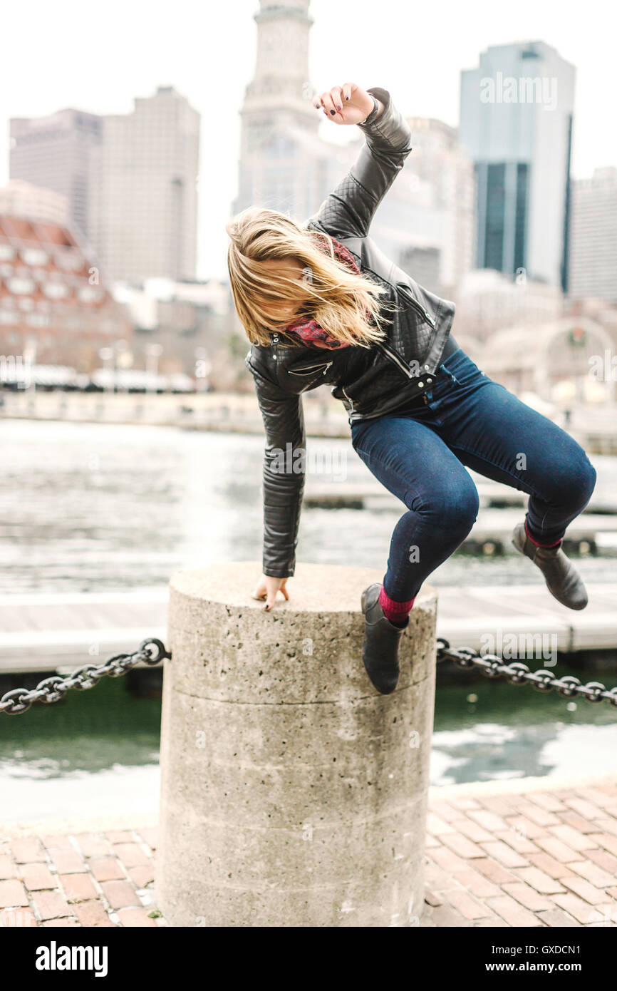 Donna saltare da un blocco di cemento armato, Boston, Massachusetts, STATI UNITI D'AMERICA Foto Stock