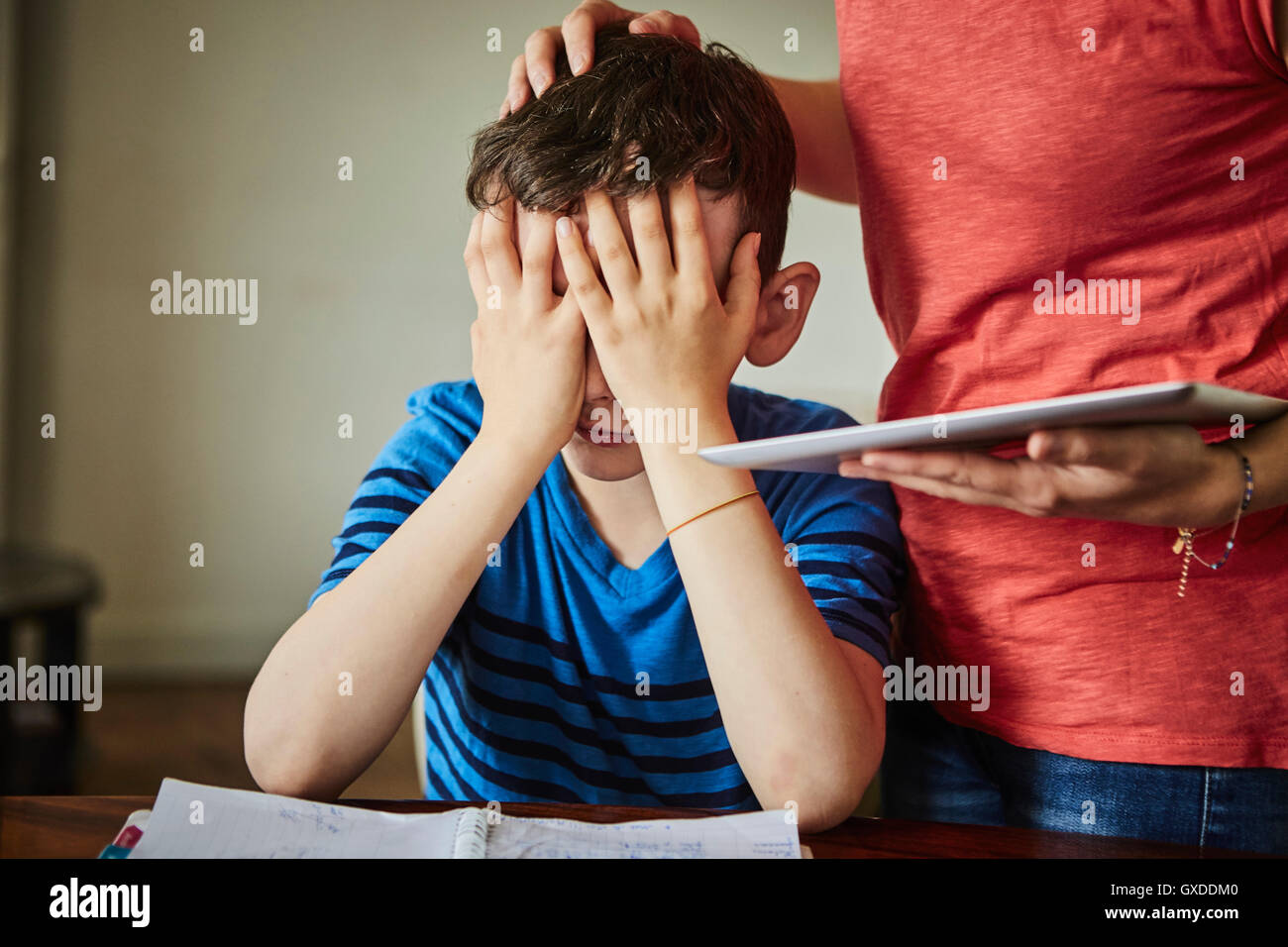 Madre consolante sconvolto figlio di fare i compiti di scuola Foto Stock