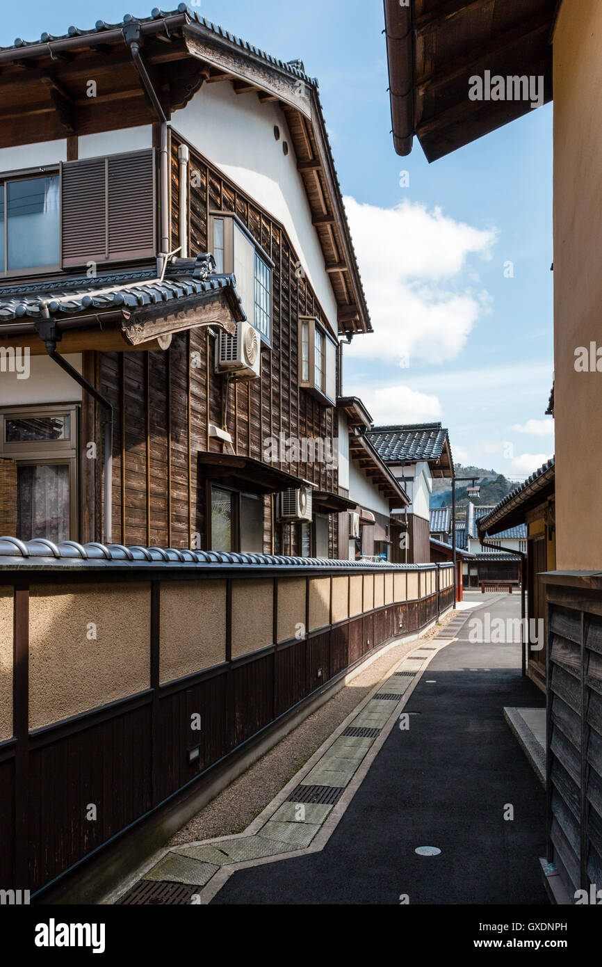 Giappone, Izushi. Il percorso stretto tra il carter, tipica giapponese di legname di grandi dimensioni e gesso housees trovati in semi-rurale. Stile tradizionale parete. Foto Stock