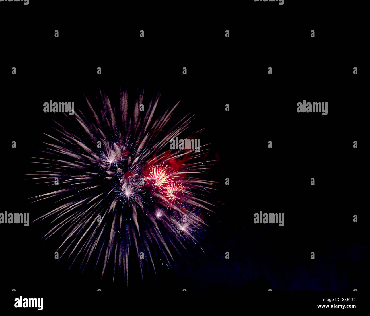Coloratissimi fuochi d' artificio brilla pattern contro il cielo scuro dello sfondo. Foto Stock