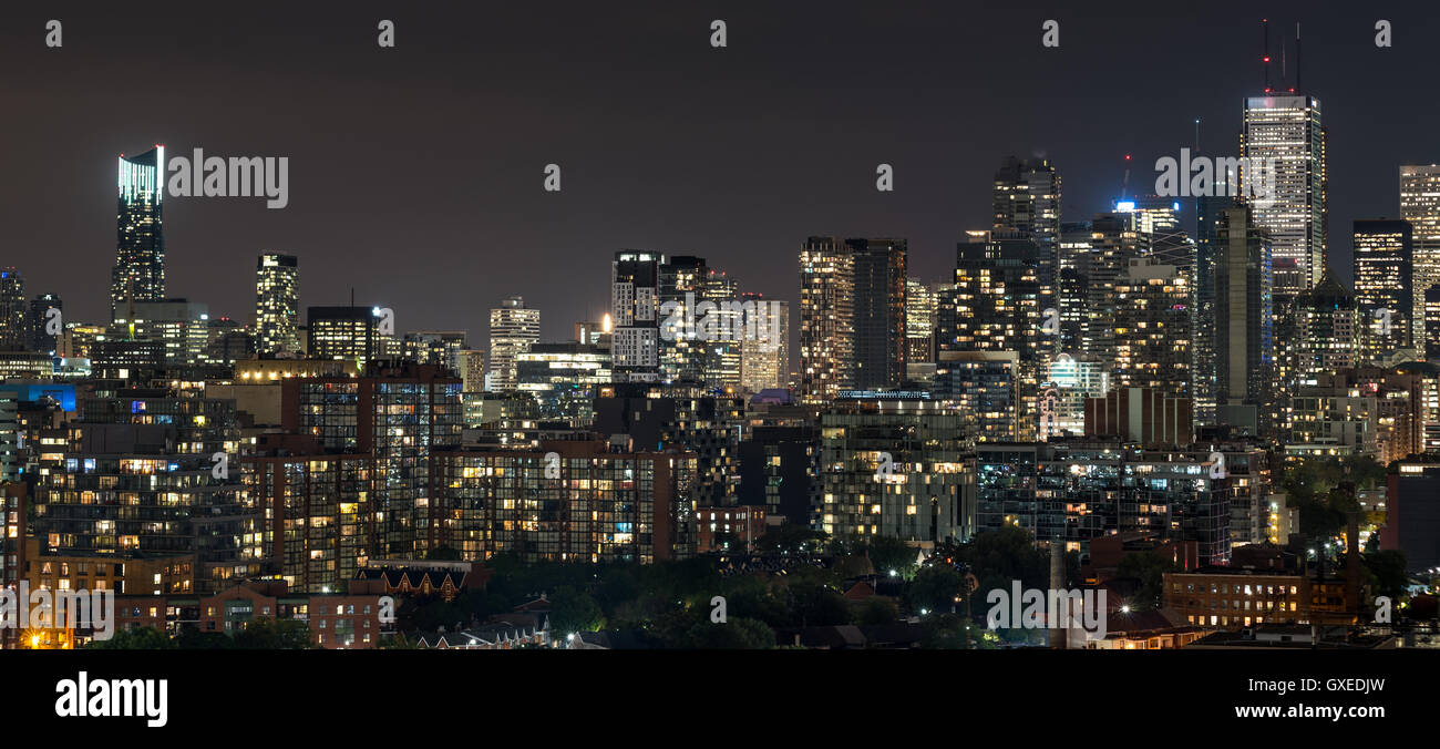 Urbano paesaggio illuminato e sullo skyline di Toronto. Una panoramica sul tetto di strade urbane, case, condomini e torri di uffici. Foto Stock