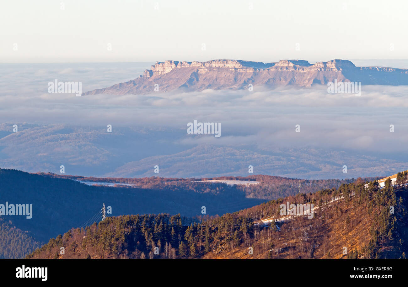 Inverno montagna paesaggio nuvole: veduta aerea della valle nella zona di montagna vicino Arkhyz (Caucaso, Russia) dalle nubi Foto Stock