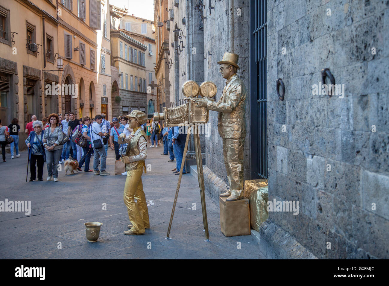 Artisti di strada a Siena, Italia. Mimi di strada agendo come old time movie camera uomo e assistente. Foto Stock