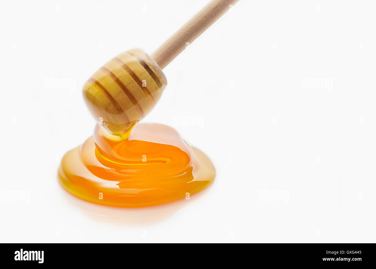 Il miele che gocciola dalla cucchiaia di miele Foto Stock