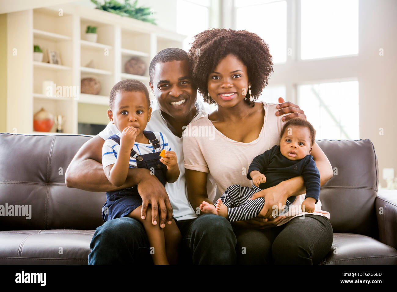 Sorridente famiglia nero in posa sul divano Foto Stock