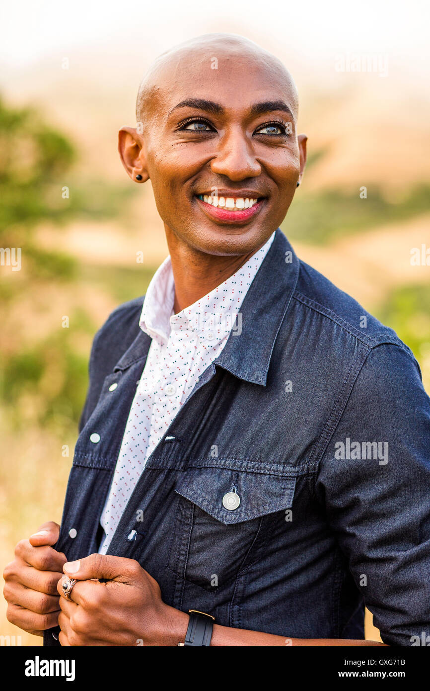 Sorridente gay uomo nero tenuta camicia denim Foto Stock