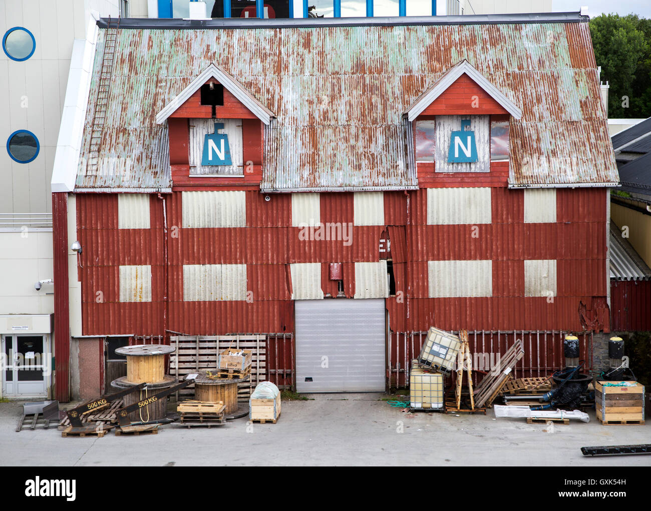 Vecchio ferro corrugato magazzino edificio waterside, Bronnoy, Bronnoysund, Nordland, Norvegia Foto Stock
