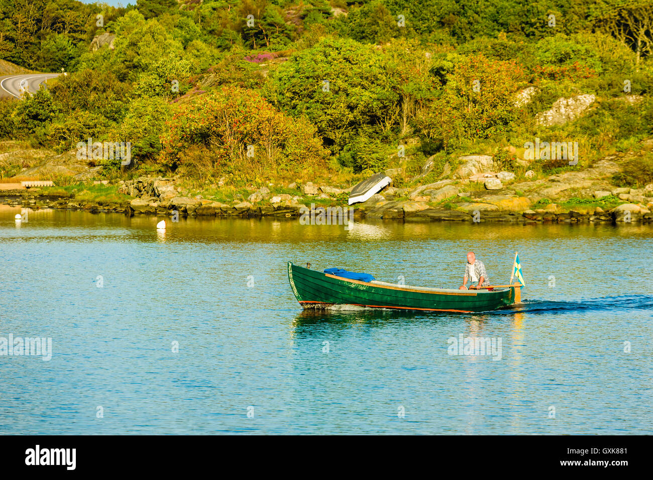 Marstrand, Svezia - 8 Settembre 2016: ambientale documentario dell uomo alla guida di un vecchio, verde motoscafo nella west coast archip Foto Stock