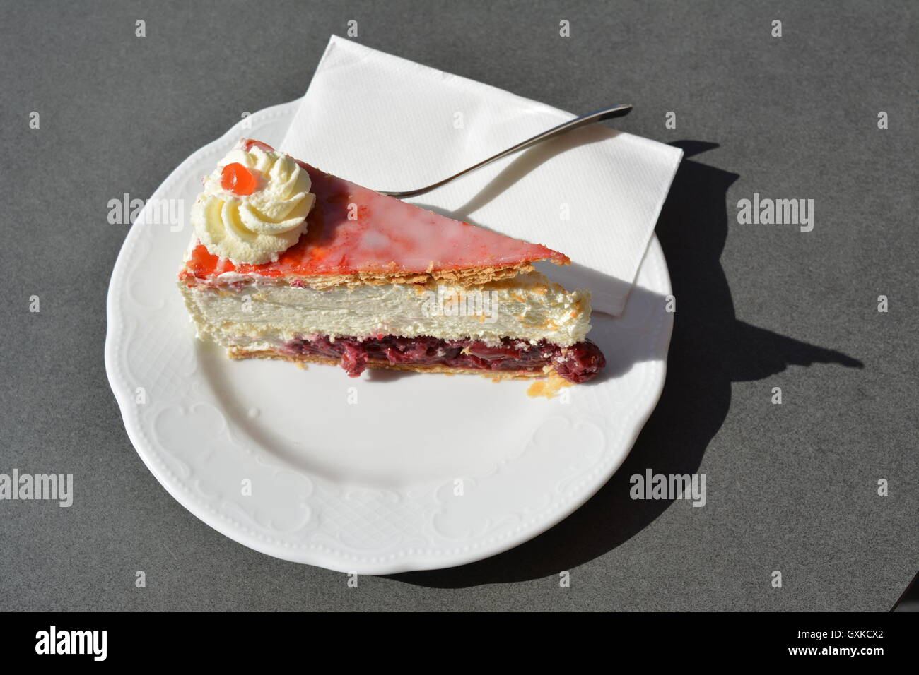 La torta di panna con ciliegie su una piastra Foto Stock